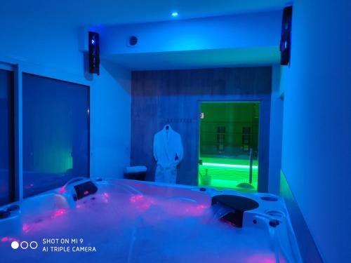 - une salle de bains bleue pourvue d'une baignoire dans l'établissement Hôtel & Spa La Villa, à Sainte-Maxime