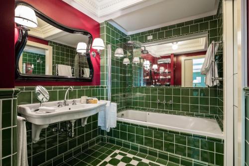 a green tiled bathroom with a tub and a sink at Hotel Regency - Small Luxury Hotels of the World in Florence