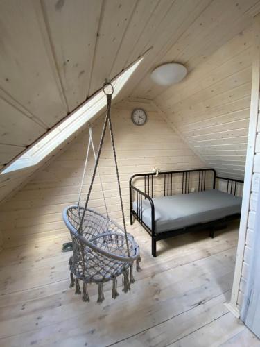 Pokój z huśtawką i łóżkiem na poddaszu w obiekcie Domek Helenka w mieście Stężyca