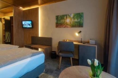 a hotel room with a bed and a desk and a chair at Gasthof Pension Renate Krupik in Steinbach