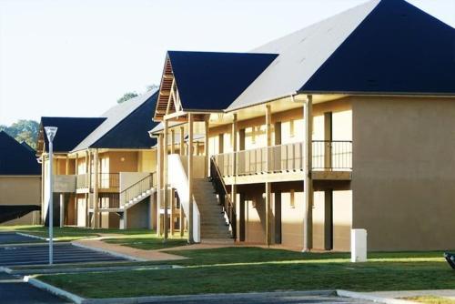 a large building with a blue roof and stairs at Entre le Pont 9 et l'Eveque , Les Hauts de Honfleur, Piscine, WIFI et Parking gratuits in Équemauville