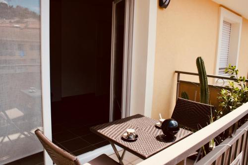 a table and chairs on a balcony with a cactus at Carpe Diem in Beaulieu-sur-Mer