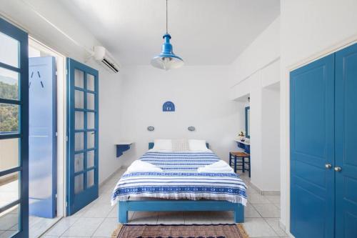 een slaapkamer met blauwe deuren en een bed erin bij Sea View Kerame in Evdilos