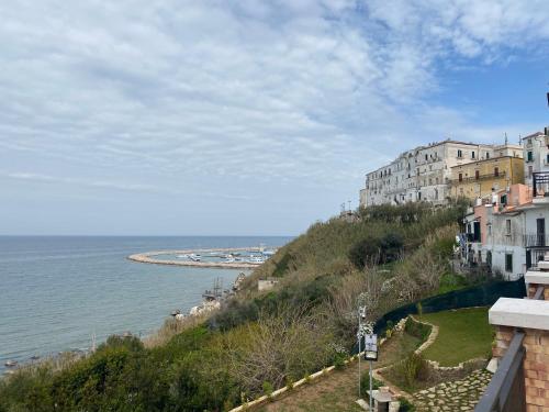a building on a hill next to the ocean at Terrazza mare home in Rodi Garganico