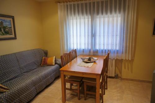 ein Wohnzimmer mit einem Tisch und einem Sofa in der Unterkunft Ca La Paletes in Cornudella de Montsant