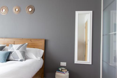 a bedroom with a bed and a mirror at Tailor That Property - Chelsea House in Milton Keynes