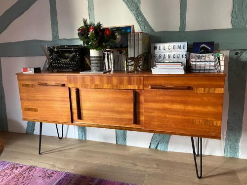 - une commode en bois avec des fleurs et des livres dans l'établissement le 4B - Le Vintage, à Rouen