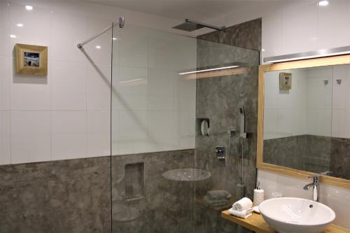 プエルト・デル・カルメンにあるDivineのバスルーム(洗面台、ガラス張りのシャワー付)