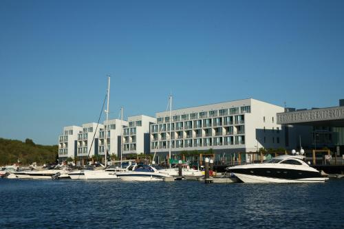 a group of boats docked in a harbor with a building at Troia Residences - Apartamentos Marina in Troia