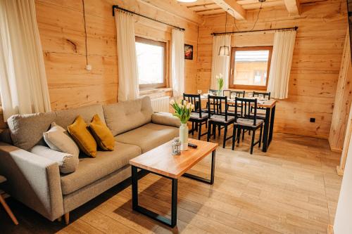 a living room with a couch and a table at Bieszczadzkie Chatki - Willa Stasia in Ustrzyki Dolne