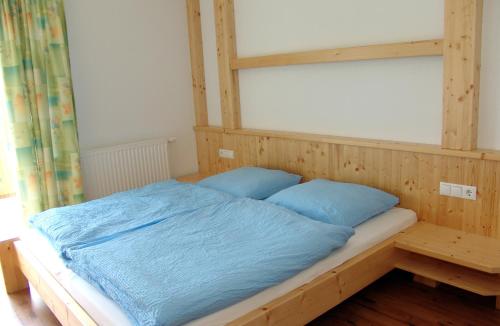 a bed with blue pillows in a room at Ferienhaus Enterberg in Ramsau im Zillertal