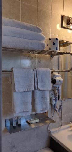 a bathroom with towels on a shelf and a sink at Pinebrook Motel in Lake George