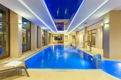 a large swimming pool in a hotel lobby at Cottonina Hotel & Mineral SPA Resort in Świeradów-Zdrój