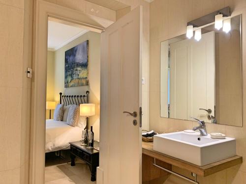 a bathroom with a white sink and a bed at Residence Lagos in Lagos