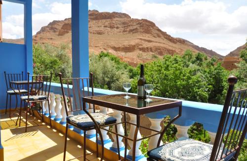 un tavolo e sedie su un balcone con vista sulle montagne di A Secret Garden a Tinerhir