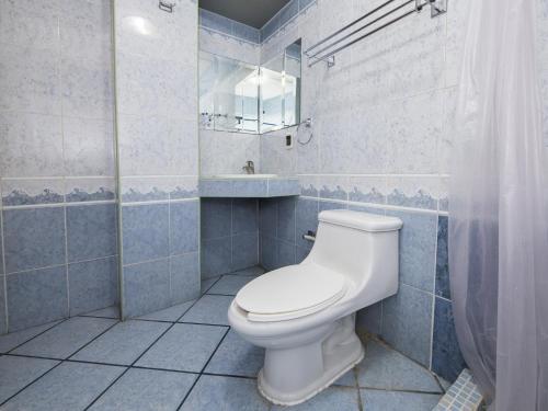 a bathroom with a white toilet and a sink at Suites de Reyes in Irapuato