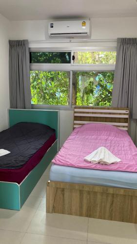 a bedroom with two beds and a window at Kata Top Villas in Kata Beach