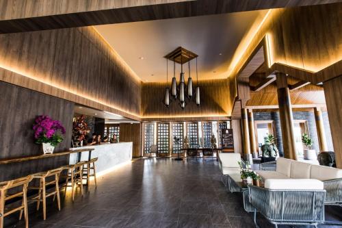 a lobby of a hotel with a bar and chairs at The Teak Hotel in Mae Sot