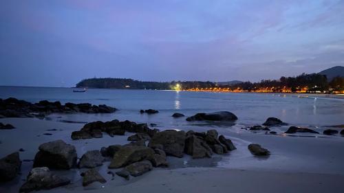 a beach with rocks in the water at night at Kata Top Villas in Kata Beach