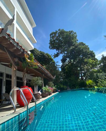 a swimming pool in front of a house at Kata Top Villas in Kata Beach