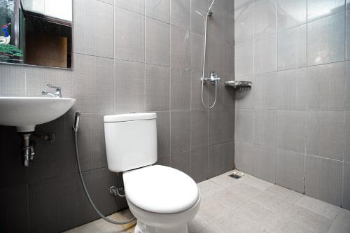 a bathroom with a toilet and a sink at RedDoorz near Palembang Trade Center 3 in Sukarami