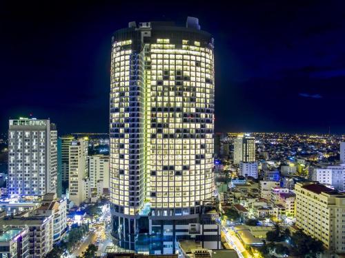 a lit up building in a city at night at PANORAMA Condotel by HLG in Nha Trang