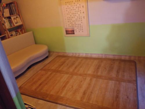 Habitación con sofá y suelo de madera. en Uwha Minbak, en Yeosu