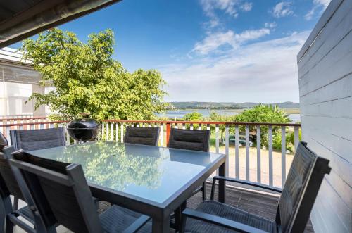 a table and chairs on a balcony with a view at 18 on Tides End in Knysna