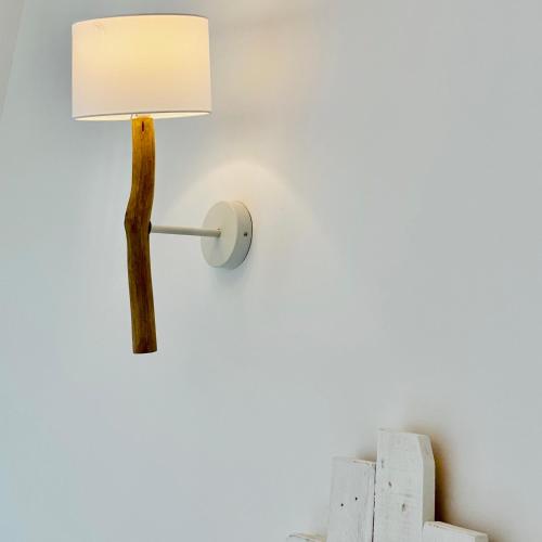 a lamp with a wooden pole attached to a wall at Residenza B&B VistaMare in Petacciato