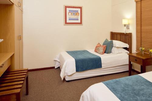 Habitación de hotel con 2 camas y mesa en First Group Port Owen Marina, en Velddrif