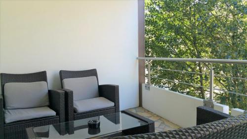 2 sillas y una mesa de cristal en el balcón en HOLI DAY SPA Appartement 2 en Berlín