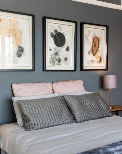 a bedroom with three framed pictures above a bed at 18 on Tides End in Knysna