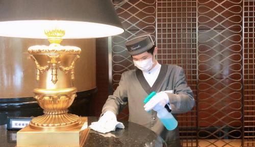 a man wearing a mask and a table with a lamp at Kempinski Hotel Shenzhen - 24 Hours Stay Privilege, Subject to Hotel Inventory in Shenzhen