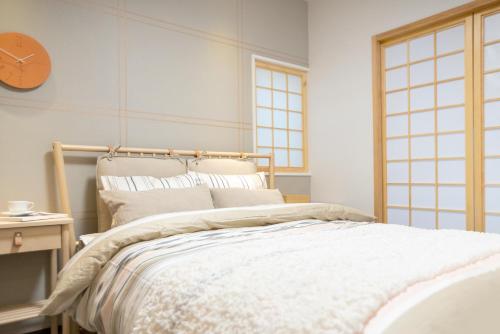 a bedroom with a bed and a clock on the wall at Tsubame Hotel Asakusabashi 3 minutes walk from Asakusabashi Station Near Asakusa, Akihabara, and Ueno Cooking utensils and kitchen washing machine available Direct access to Haneda and Narita airports in Tokyo