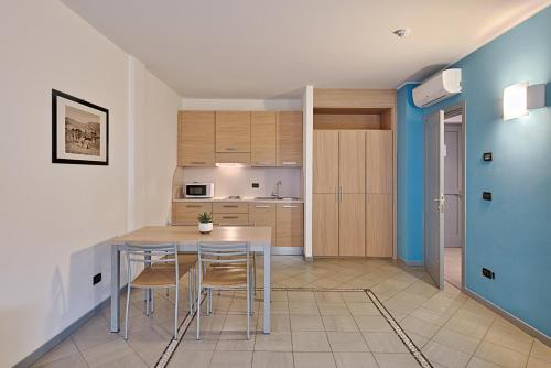 a kitchen with a table and chairs in a room at Aregai Marina Hotel & Residence in Santo Stefano al Mare