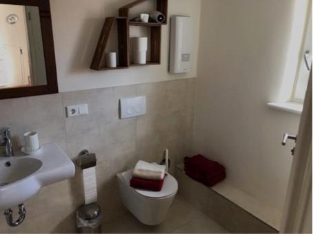 a bathroom with a white toilet and a sink at Wohlfühl Appartments in Felsberg