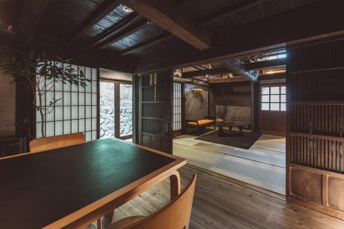 a dining room with a green table and chairs at NIPPONIA Kosuge Village in Kosuge