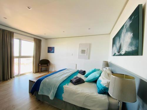 a bedroom with a large bed with blue pillows at Waterside Apartment in Gansbaai