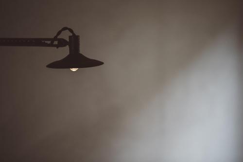 a black lamp hanging on a wall at NIPPONIA Kosuge Village in Kosuge