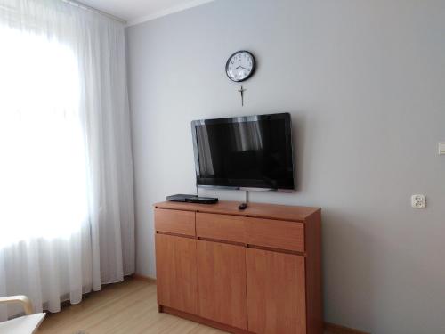 オルシュティンにあるMieszkanie w Kamienicy przy Starówceの木製ドレッサーの上にテレビが付いています。