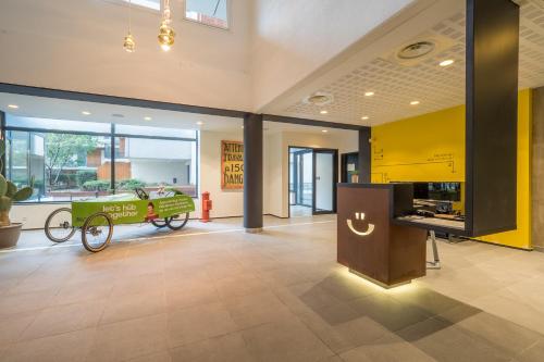 a lobby with a cart in the middle of a building at Apparthotel Le Hüb Grenoble in Grenoble
