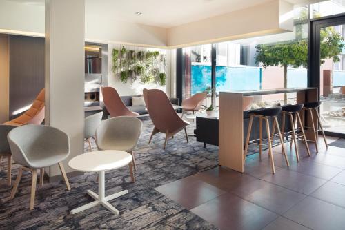 a lobby with chairs and a bar in a building at Novotel Lausanne Bussigny in Lausanne