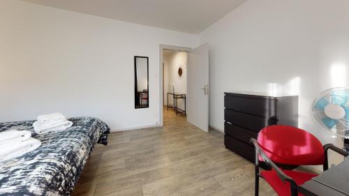 コルマールにあるLes Charpentiersのベッドルーム1室(ベッド1台、デスク、赤い椅子付)