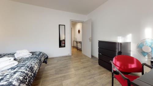 a bedroom with a bed and a desk and a red chair at Les Charpentiers in Colmar