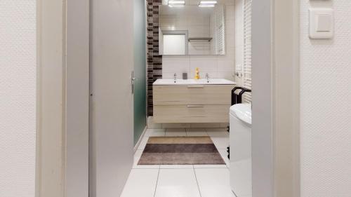 a small bathroom with a sink and a mirror at Les Charpentiers in Colmar