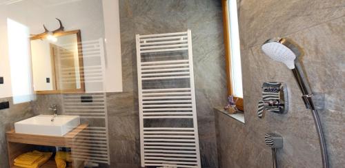 a bathroom with a shower with a sink and a mirror at Felderhof in Maranza