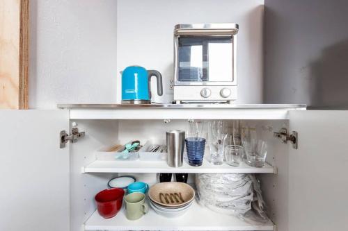 a kitchen cabinet with a coffee maker on top of it at THE EAST AVENUE in Sapporo