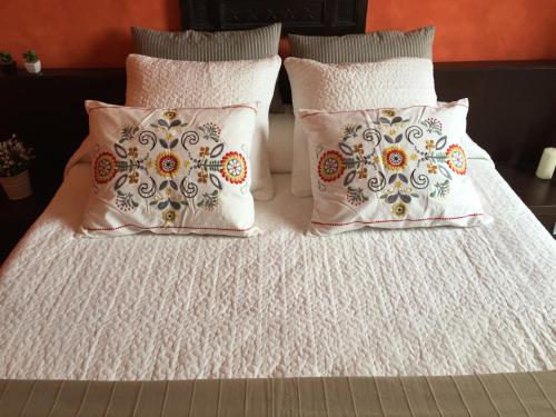 2 almohadas y 1 cama con sábanas blancas en Hotel Villa San Fedele, en San Fedele Intelvi