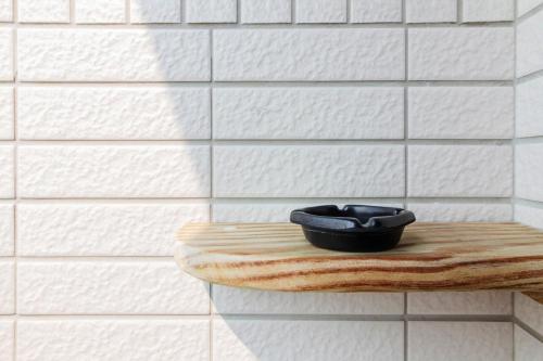 a black bowl sitting on a wooden shelf in a bathroom at 98Inn in Xiaoliuqiu