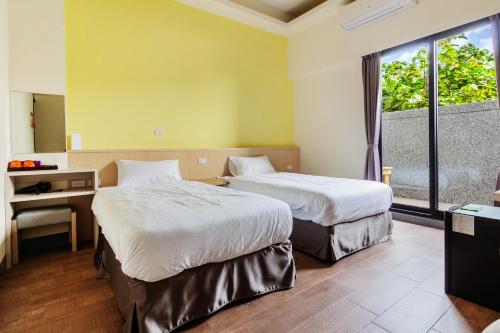 a hotel room with two beds and a window at 98Inn in Xiaoliuqiu